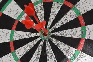 Collection of Darts in the Center of a Dartboard photo