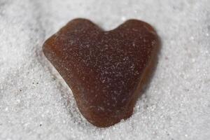 Brown Heart Shaped Beach Glass on Sand Beach photo