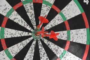 Dartboard with a Trio of Darts Near Bullseye photo