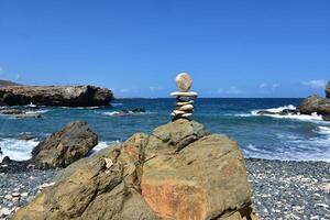 pila de rocas equilibrio al aire libre por el costa foto