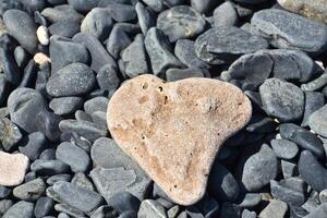 Naturally Formed Heart Shaped Stone on Darker Stones photo