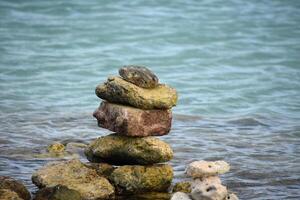 rocas apilado y equilibrio por el agua foto