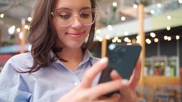 een vrouw in bril gebruik makend van haar telefoon video