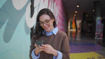 een vrouw in bril gebruik makend van haar telefoon video