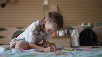 a young girl is sitting on the floor and drawing video