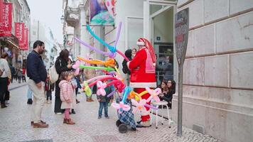 a man dressed as santa claus is making animal baloon video