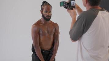 uma masculino modelo é fazendo sessão de fotos sessão dentro frente do uma branco fundo video