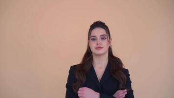 porträtt av en ung företag kvinna med vapen korsade på en beige bakgrund video