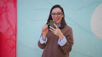 un mujer en lentes tomando un selfie con un teléfono inteligente video