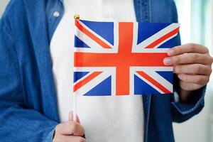 Learning English, Asian teenage student holding flag for language program education. photo