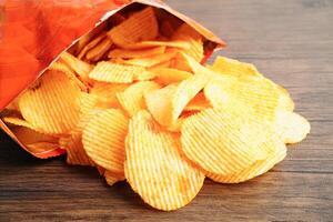 Potato chips in open bag, delicious BBQ seasoning spicy for crips, thin slice deep fried snack fast food. photo