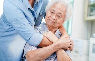 Caregiver holding hands Asian elderly woman patient, help and care in hospital. photo