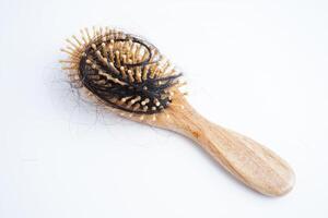 Caída de pérdida de cabello con cepillo de peine aislado sobre fondo blanco. foto