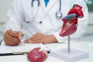 cardiovascular enfermedad CVD, médico con corazón humano modelo anatomía para tratamiento paciente en hospital. foto