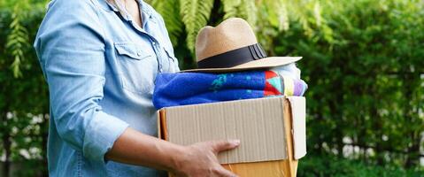 Volunteer collect cloth and hat in cardboard box to donate. photo