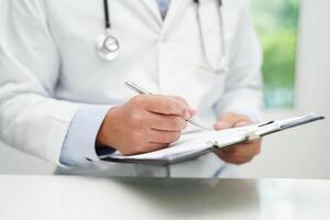 asiático hombre médico estudiar documento a investigación método y técnica para tratando pacientes foto