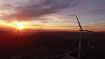 Puissance vent turbines dans le montagnes à le coucher du soleil aérien vue video