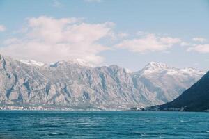 turquesa mar a el pie de un alto montaña rango con nevadas picos montenegro foto