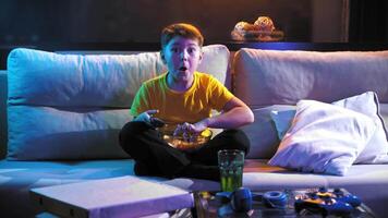 een jongen is aan het kijken een film terwijl aan het eten chips. video