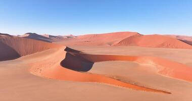 Drönare flyg över de lysande röd sand sanddyner av de namib öken- i sossusvlei tidigt i de morgon- video