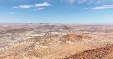 Drone video of a flight along the Spitzkoppe in Namibia during the day against a blue sky