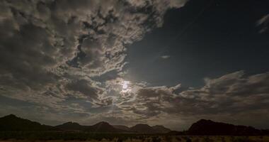 giorno per notte tempo periodo film di il notte cielo al di sopra di namibia con veloce in movimento nuvole nel davanti di il pieno Luna video