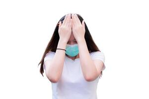 Stressed woman holding her head in pain, feeling upset, Person wearing green medical face mask, On isolated background. photo