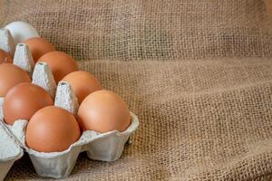 Fresh chicken eggs in a paper tray on the table, selective focus photo