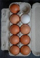 Fresh chicken eggs in a paper tray on the table, selective focus photo