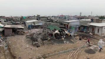 aéreo cenas do barcos ancorado às a cais dentro uma favela e densamente populosa área dentro cilíndrico, tanjung priok, norte Jacarta - perahu kayu Bersandar di dermaga Wilayah kumuh padat penduduk 4k zangão video