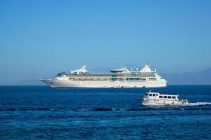 Boat and cruise liner is Aegean sea. Chora, Mykonos island, Greece photo