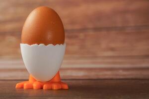Fresco huevo en un huevo taza en el forma de un pollo foto