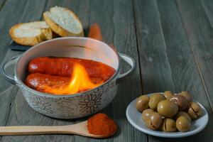 typical spanish tapa ,chorizo al infierno in ceramic casserole photo