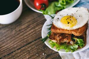 Sandwich with eggs, chicken, cucumber and lettuce on a wooden background. Selective focus. copy space photo