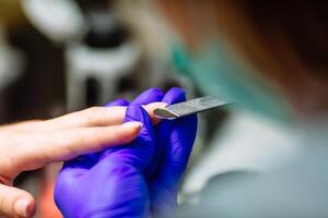 Manicure care procedure, Woman in a nail salon receiving a manicure by a beautician. Closeup shot. photo