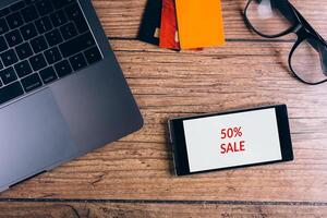 Smartphone on wooden table. Black friday advert. Top view. photo