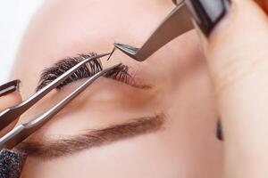 Eyelash Extension Procedure. Woman Eye with Long Eyelashes. Lashes, close up, macro, selective focus. photo