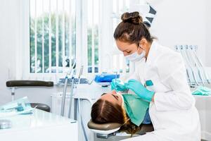 hembra dentista comprobación arriba paciente dientes con tirantes a dental clínica oficina. medicamento, odontología concepto. dental equipo foto