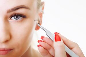 Eyelash Extension Procedure. Woman Eye with Long Eyelashes. Close up, selective focus. photo