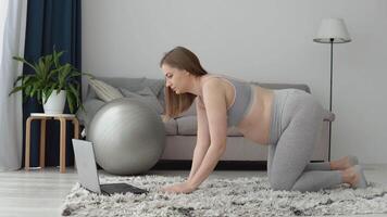 grávida mulher dentro roupa de esporte fazendo exercícios às casa dentro a vivo sala. saúde Cuidado durante gravidez. Esportes para grávida mulheres video