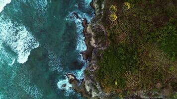 Beautiful cave rocky beach with blue water on sunrise in tropics. Aerial Drone video