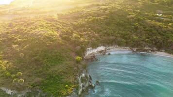 lindo caverna rochoso de praia com azul água em nascer do sol dentro trópicos. aéreo zangão video