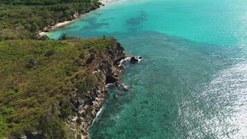 Colorful waters of the ocean, swirl around the rocky and scenic coastline. Sea waves breaking over rocks. Ttropical island. Turquoise ocean. Caribbean Sea. Flying forward. video