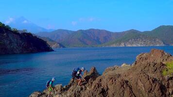 Boys with backpacks traveler in the mountains along the coast of the Mediterranean Sea. The concept of adventure and new discoveries. video