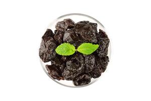 Dried plum in a glass bowl isolated on a white background top view photo