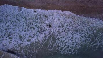 aéreo topo Visão ondas pausa em de praia. mar ondas em a lindo de praia aéreo Visão drone. 4k video