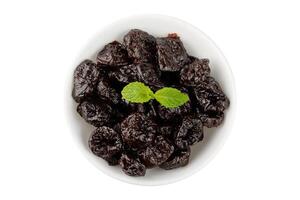 Dried plum in ceramic bowl isolated on a white background top view photo