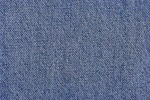 Macro photo of denim fabric with soft focus. Texture of blue jeans as a background.