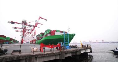 A large ship near the container wharf in Tokyo cloudy day wide shot video