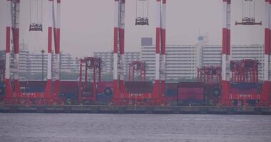 A moving large ship near the container wharf in Tokyo cloudy day long shot video